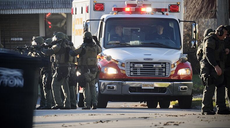 Dayton SWAT members have weapons drawn as an ambulance arrives after officers shot a 21-year-old man Tuesday, Dec. 14, 2021, near Hoover and Evergreen avenues. The man ran from  a house with a gun in his hand following a nearly three-hour standoff. Officers shot and killed the man.  MARSHALL GORBY/STAFF