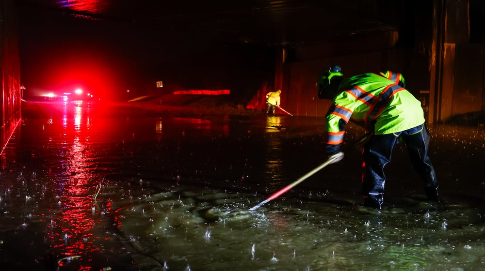Dustin Carpenter from Ohio Department of Transportation works to clear drains on a flooded Germantown Road early Thursday morning, March 5, 2026 in Madison Township in Butler County. Heavy rain caused flooding in many areas. NICK GRAHAM/STAFF
