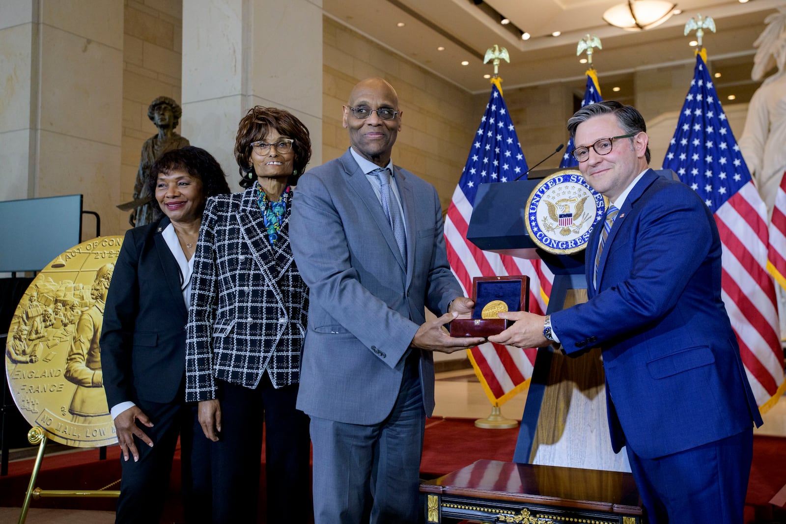 House Speaker Mike Johnson, R-La., right, presents the Congressional Gold Medal to Stanley Earley III, son of Lt. Col. Charity Adams Earley, second from right, her daughter Judith Earley, second from left, and retired Army Col. Edna W. Cummings, during a ceremony honoring the Six Triple Eight, on Capitol Hill, Tuesday, April 29, 2025, in Washington. (AP Photo/Rod Lamkey, Jr.)