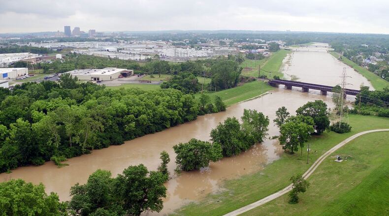 Heavy rain has the Great Miami River creeping out of its normal channel near the Kittyhawk Golf Course in Dayton on Monday. TY GREENLEES / STAFF
