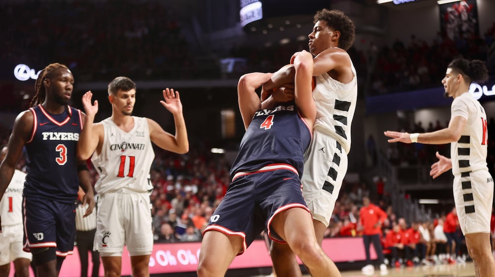 Dayton's Jordan Derkack is fouled by Cincinnati's Baba Miller in the first half on Tuesday, Nov. 11, 2025, at Fifth Third Arena in Cincinnati. David Jablonski/Staff