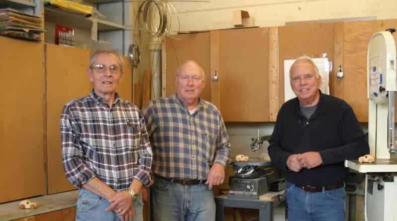 Ron Agnor (from left), Terry Holdcraft and Ron Marks volunteer in the large wood shop at St. Leonard in Centerville crafting tiny wooden cars for children all over the world. (Not pictured: Bob Cooper.) PAMELA DILLON/CONTRIBUTED