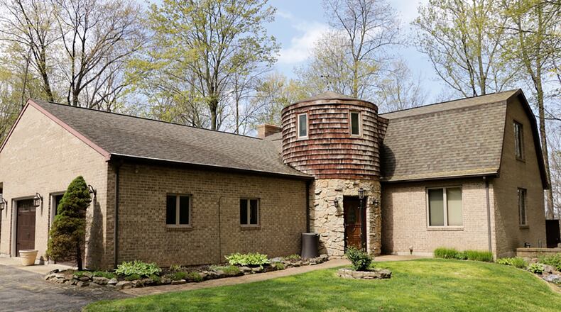 Tucked at the end of a private lane, this custom-built brick home has about 2,780 sq. ft. of living space on a full, walk-out basement. Rock-trimmed landscaping surrounds the main residence, which is through the silo or turret. A second brick building offers space for multiple uses. CONTRIBUTED PHOTO BY KATHY TYLER