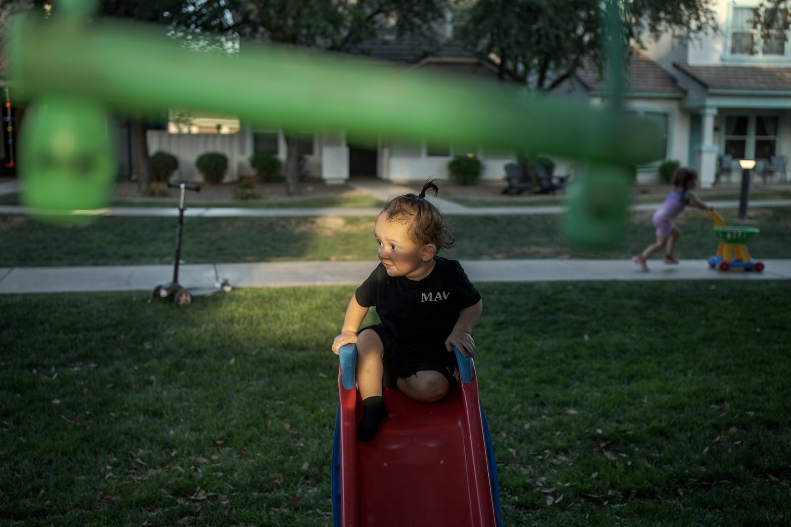 Liam Guerena plays in a "kid pod," a cluster of families with more than 20 kids between them, at Agritopia, a community nestled around a plot of agricultural land, April 21, 2025, in Gilbert, Ariz. (AP Photo/Annika Hammerschlag)
