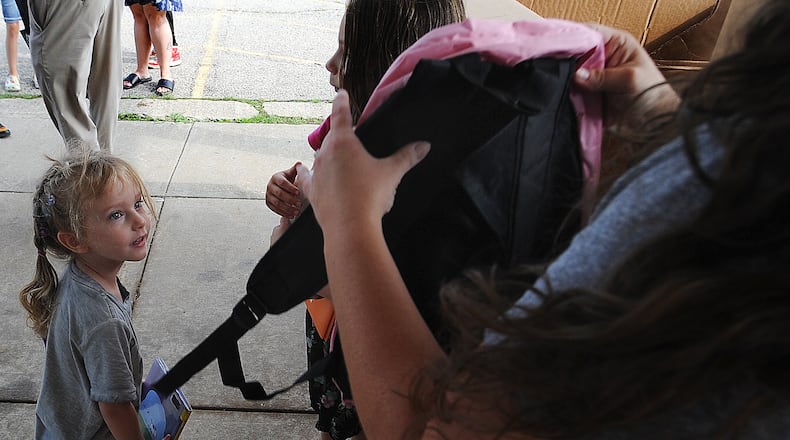 Pre-school student Anna Hattery, age 3, looks at her new free pink backpack Friday, Aug. 25, 2023 at the Overlook Community Center. As students get ready to go back to school at Mad River Schools, the district is doing its part to help ease the burden of buying schools supplies. MARSHALL GORBY\STAFF