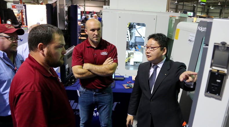 Finding the right workers and controlling costs are among the top worries that Dayton Region Manufacturers Association members have, according to a just-released survey from DRMA. In this 2015 photo, a production manager demonstrates a CNC multi-axis mill turn machine at DRMA’s annual trade show. JIM WITMER/STAFF
