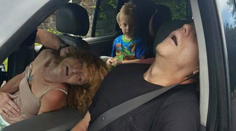 In this Wednesday, Sept. 7, 2016 photo released by the East Liverpool Police Department, a young child sits in a vehicle behind his mother and a man, both of whom are unconscious from a drug overdose, in East Liverpool, Ohio. Drug overdoses killed a record 3,050 people in Ohio last year. AP Photo.