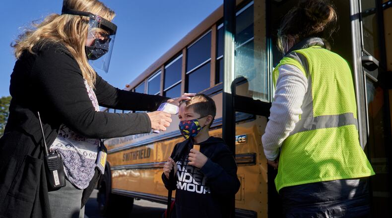 FILE- A student’s temperature is taken at an elementary school in Smithfield, R.I., Oct. 8, 2020. Researchers once feared that school reopenings might spread the coronavirus through communities. But so far there is little evidence that it’s happening. (David Degner/The New York Times)