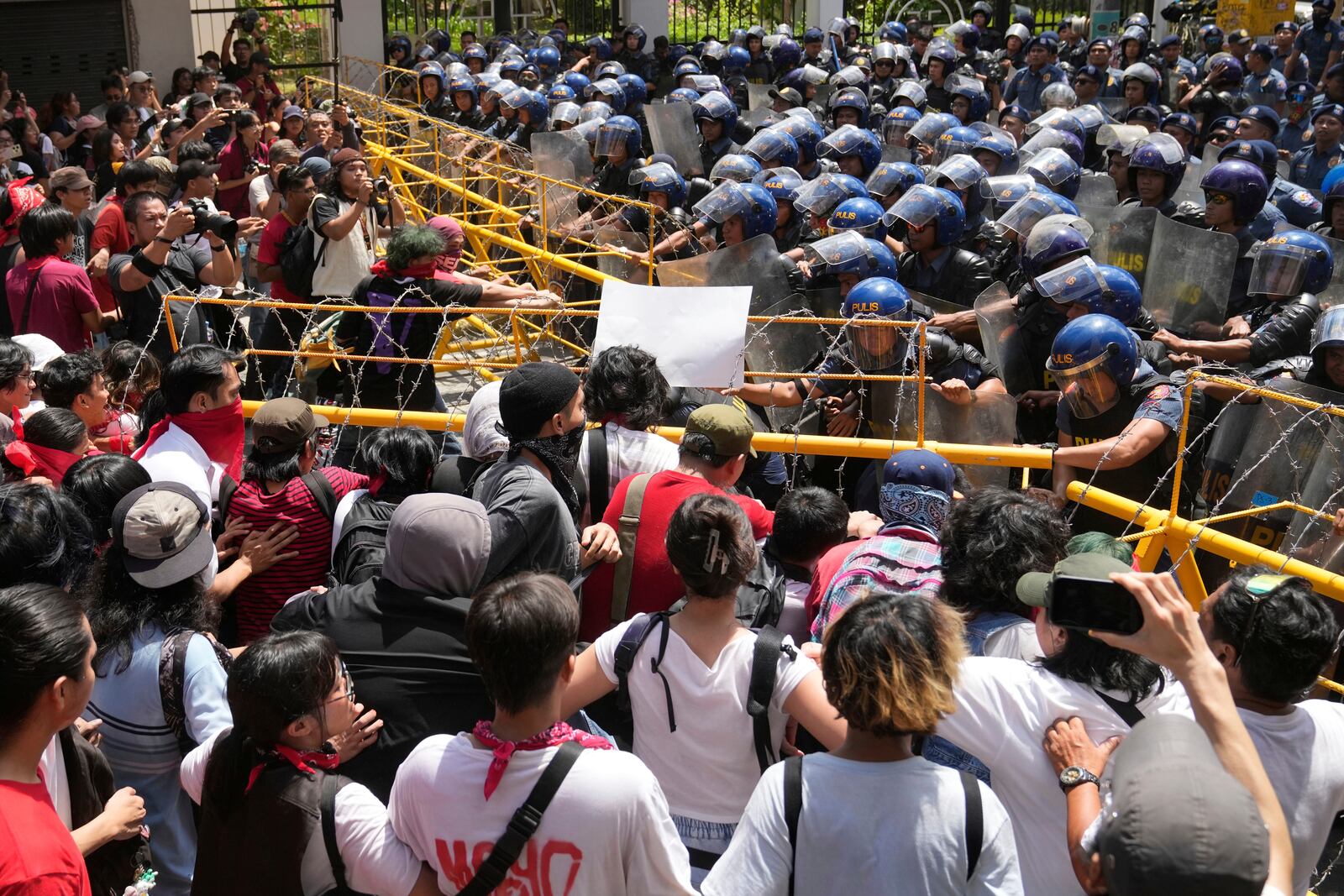 Activists and workers remove barricades as they try to march towards the Malacanang presidential palace during a May Day rally in Manila, Philippines on Thursday, May 1, 2025. (AP Photo/Aaron Favila)