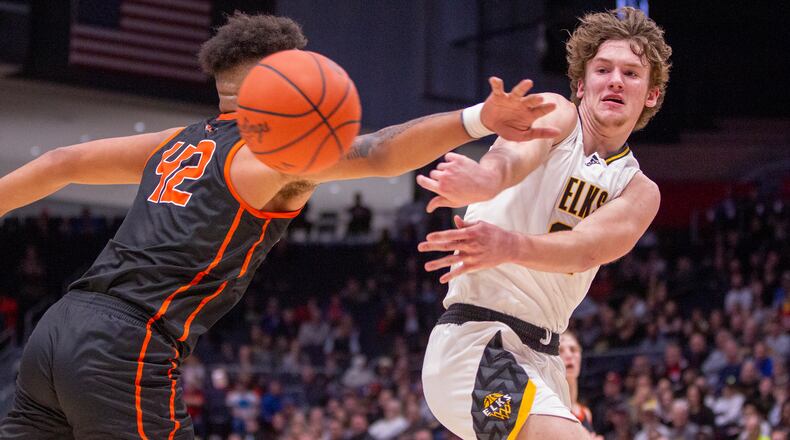 Centerville's Kyle Kenney passes to an open shooter around Cincinnati Anderson's Chandler Starks during the Elks' district final victory Saturday at UD Arena. CONTRIBUTED/Jeff Gilbert