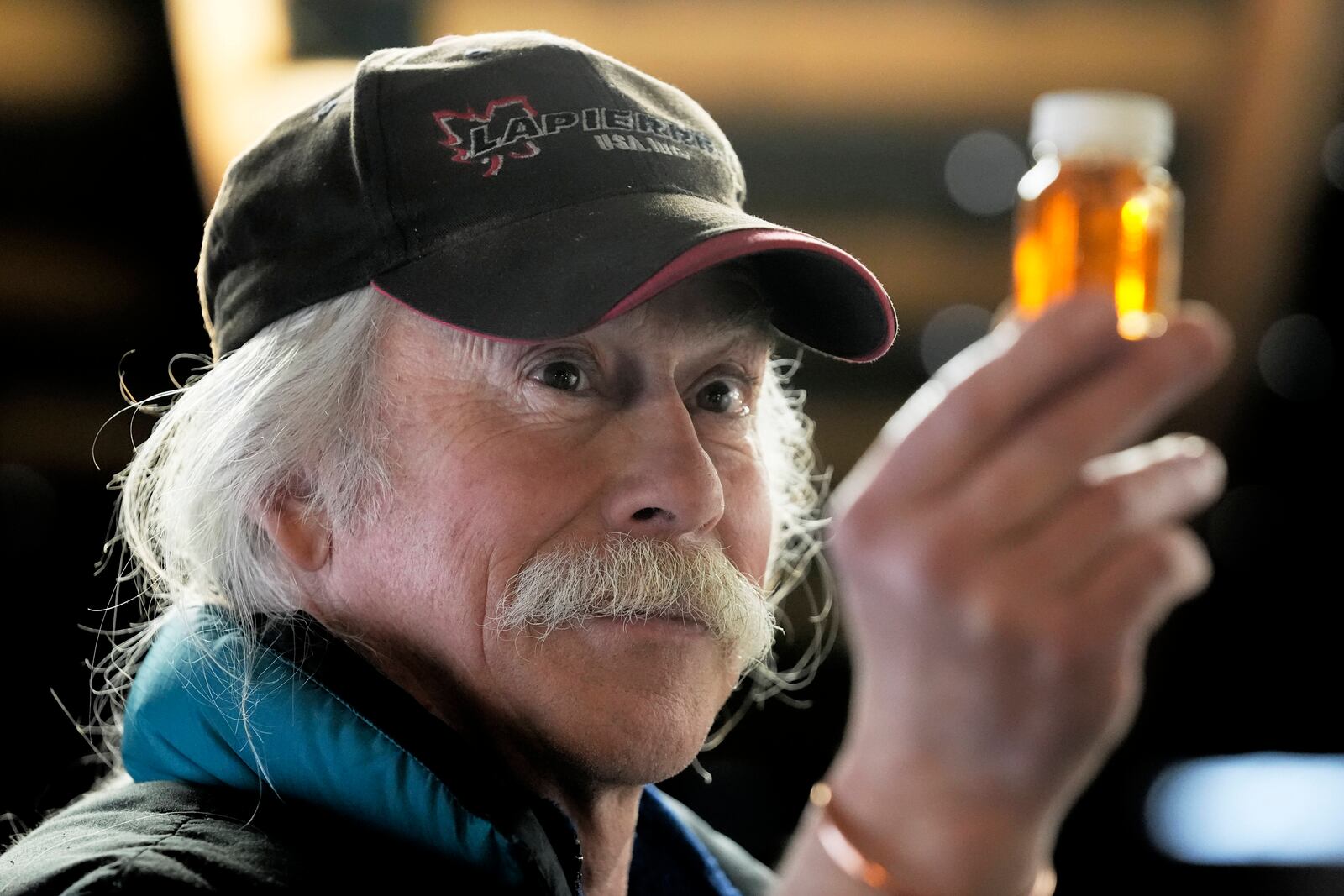 Maple syrup producer Jim Judd looks a sample of maple syrup at Judd's Wayeeses Farms in Morgan, Vt., on Friday, April 11, 2025. (AP Photo/Robert F. Bukaty)