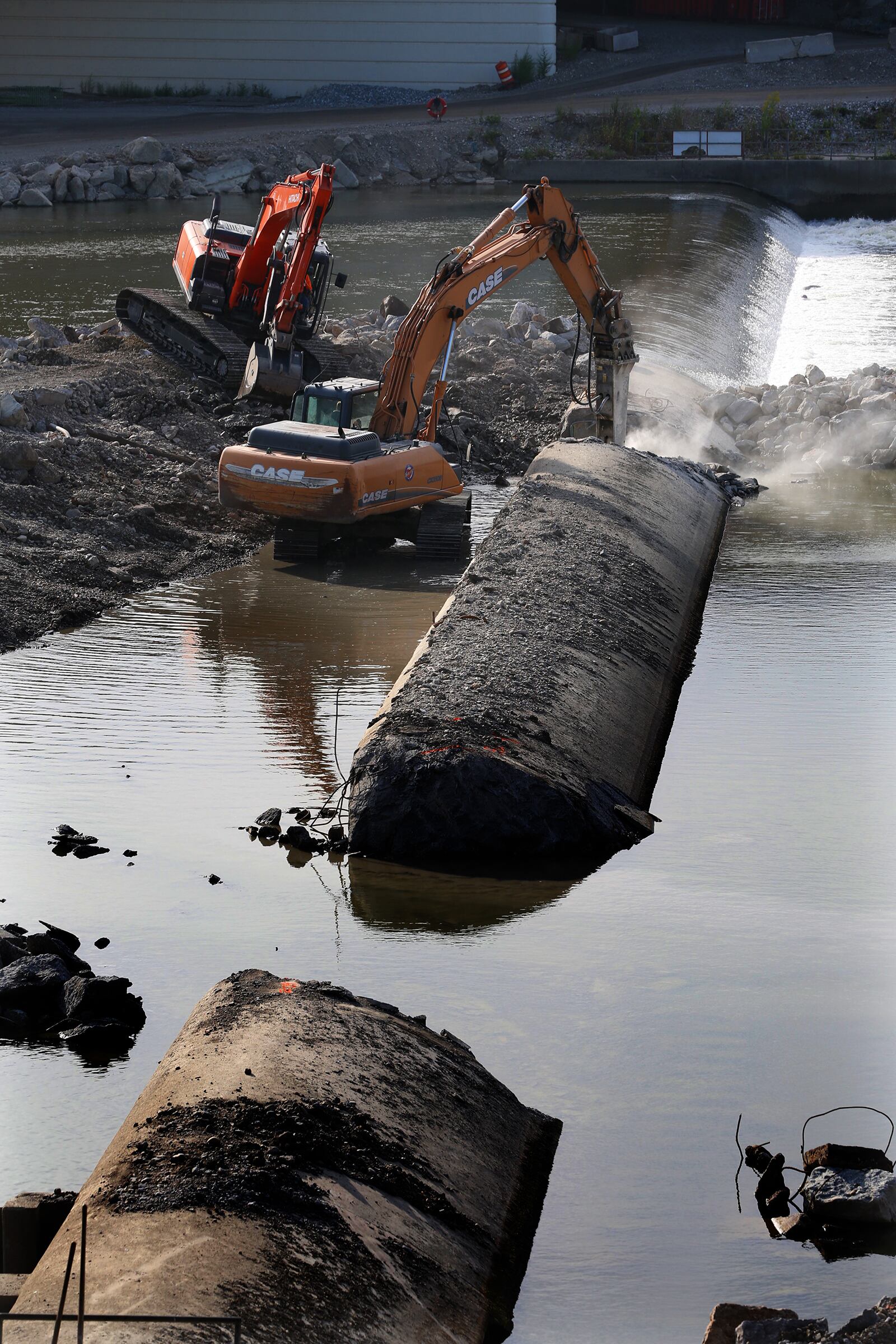 Construction crews broke through and began removing portions of the  Monument Avenue low dam, built in 1978, this week. The area will be transformed into the second drop of the RiverScape River Run fast-water kayak and canoe recreation feature. Limestone boulders will top the dam's foundation and a similar limestone boulder structure will also stretch from riverbank to riverbank upriver at RiverScape. LISA POWELL / STAFF
