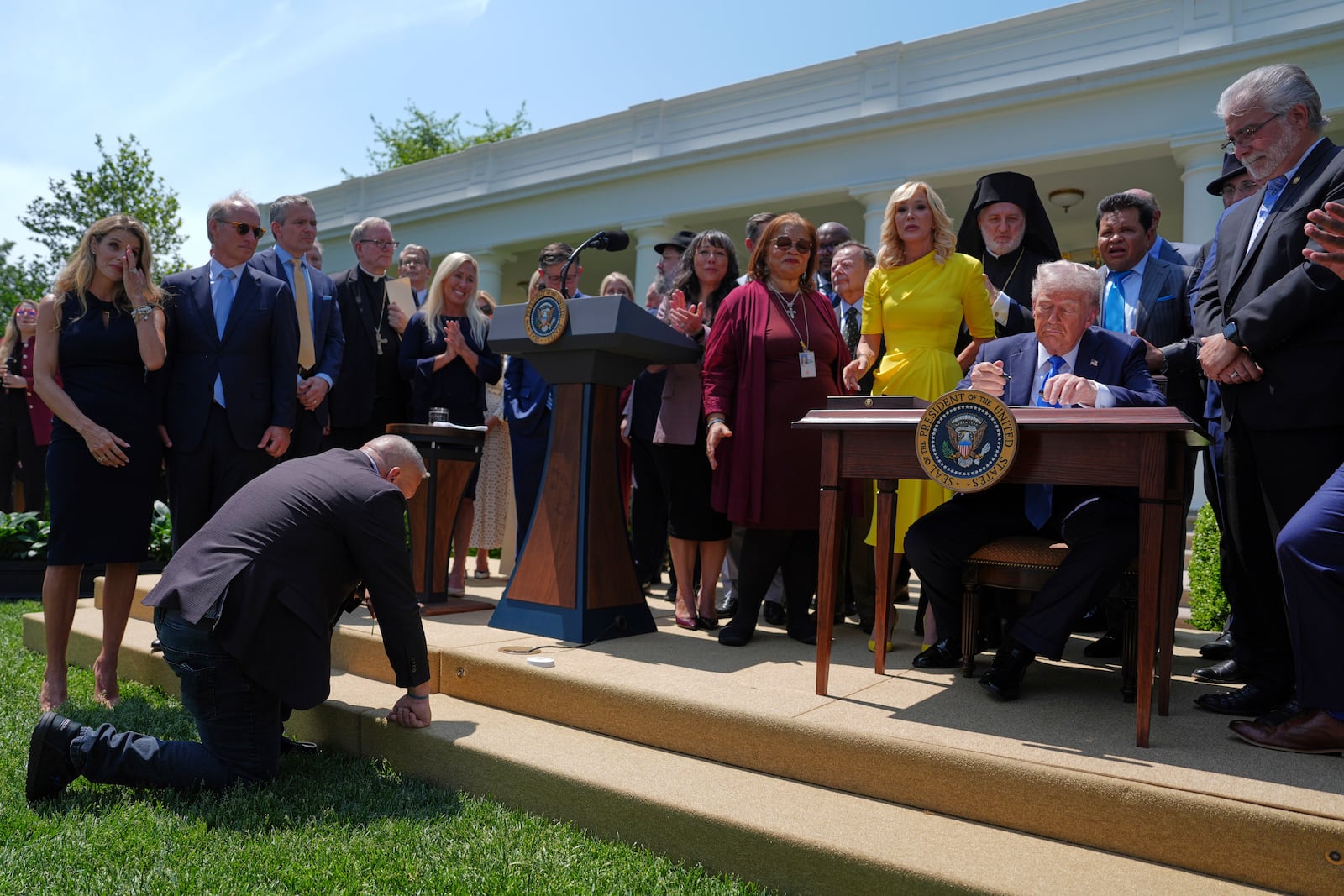President Donald Trump, surrounded by religious leaders, signs an executive order establishing the Religious Liberty Commission, during a National Day of Prayer event in the Rose Garden of the White House, Thursday, May 1, 2025, in Washington. (AP Photo/Evan Vucci)