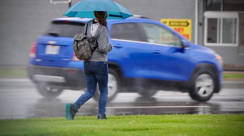It's a good day to have a umbrella if you're out and about. Here is a person walking on N. Dixie Dr. Thursday April 29, 2021. There will be showers and storms most of the day.