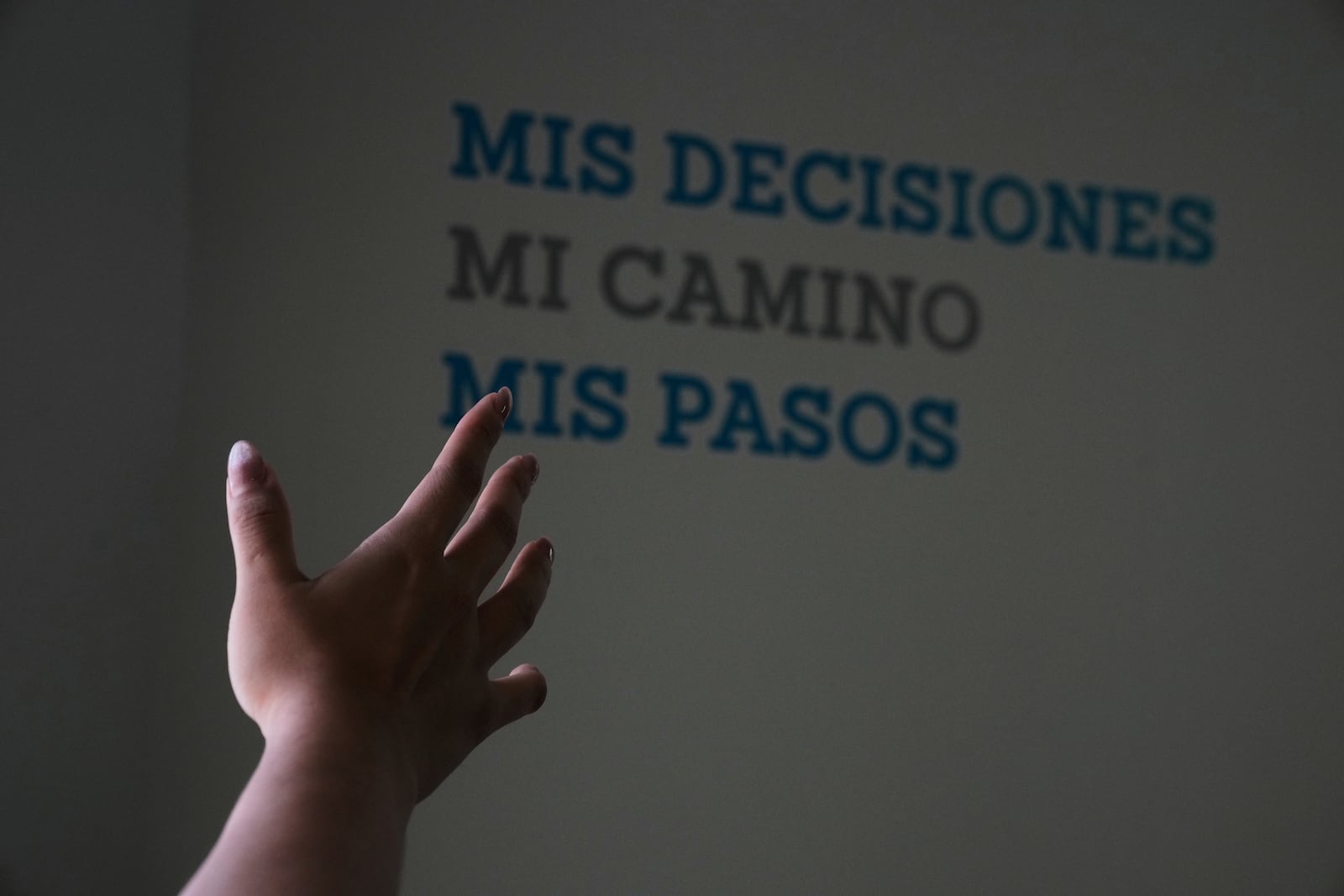 A health worker gestures towards a message that reads in Spanish; "My decisions, my road, my steps" during a tour of the MSI Foundation, an organization that offers information and help to women seeking abortions, in Mexico City, Thursday, May 8, 2025. (AP Photo/Marco Ugarte)