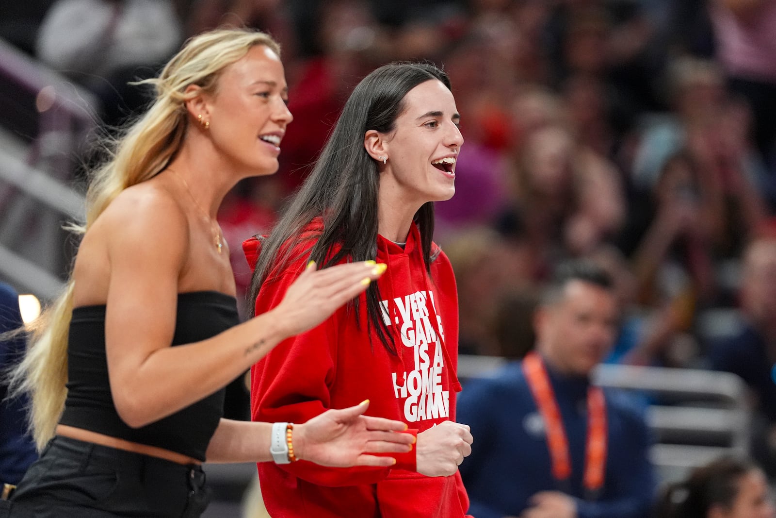 Indiana Fever guard Caitlin Clark, right, and guard Sophie Cunningham celebrates on the bench in the first half of a WNBA basketball game against the Washington Mystics in Indianapolis, Tuesday, June 3, 2025. (AP Photo/Michael Conroy)