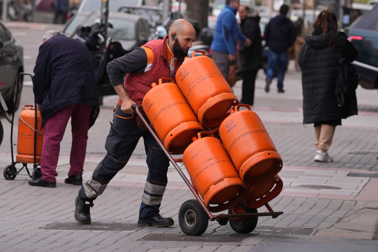 FILE -A worker delivers butane gas bottles in Madrid, Spain, Monday, March 28, 2022. (AP Photo/Paul White, File)