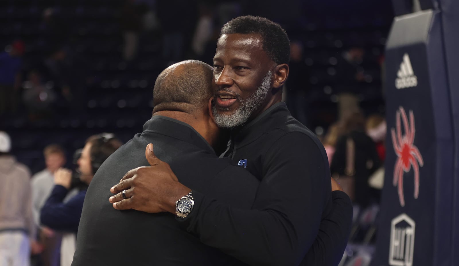 Dayton's Anthony Grant, right, hugs Jermaine Henderson after a victory against Richmond on Tuesday, March 3, 2026, at the Robins Center in Richmond, Va. David Jablonski/Staff