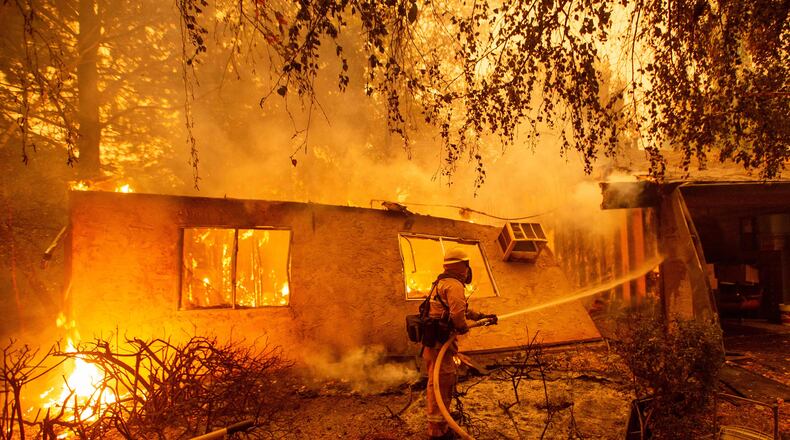 Firefighters battle flames at a burning apartment complex in Paradise, north of Sacramento, Calif. on Nov. 09, 2018. A rapidly spreading, late-season wildfire in northern California has burned 20,000 acres of land and prompted authorities to issue evacuation orders for thousands of people. As many as 1000 homes, a hospital, a Safeway store and scores of other structures have burned in the area as the Camp fire tore through the region.