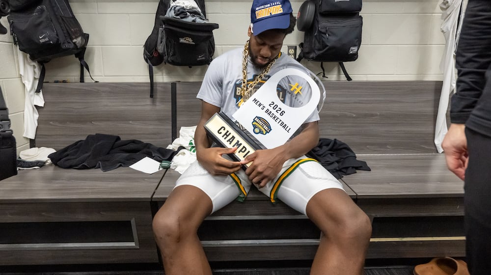 Wright State University's Michael Imariagbe holds the trophy in the locker room after their 66-63 victory over Detroit Mercy in the Horizon League tournament final on Tuesday, March 10, 2026 at Corteva Coliseum in Indianapolis. HORIZON LEAGUE / CONTRIBUTED PHOTO