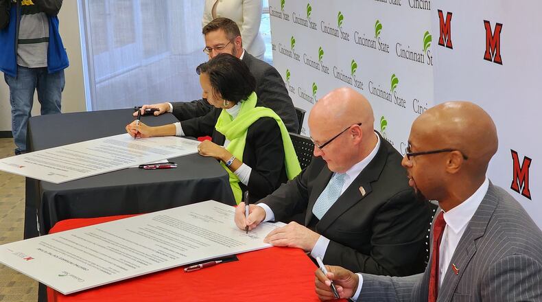 Front to back: Miami Regionals Dean and Vice President Ande Durojaiye, Miami University President Gregory Crawford, Cincinnati State President Monica Posey and Cincinnati State Provost Robbin Hoopes sign their "Creating Pathways for the Future" agreement during a press conference event to share information about a partnership between the two schools Monday, Dec. 5, 2022 at Miami University Middletown campus. NICK GRAHAM/STAFF