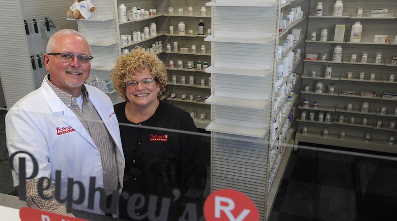 Bruce Pelhrey, RPh, with his wife Lisa, stand behind the corner of their new business, Pelphrey's Pharmacy, located at 7208 Tayorsville Road in Huber Heights. MARSHALL GORBY\STAFF