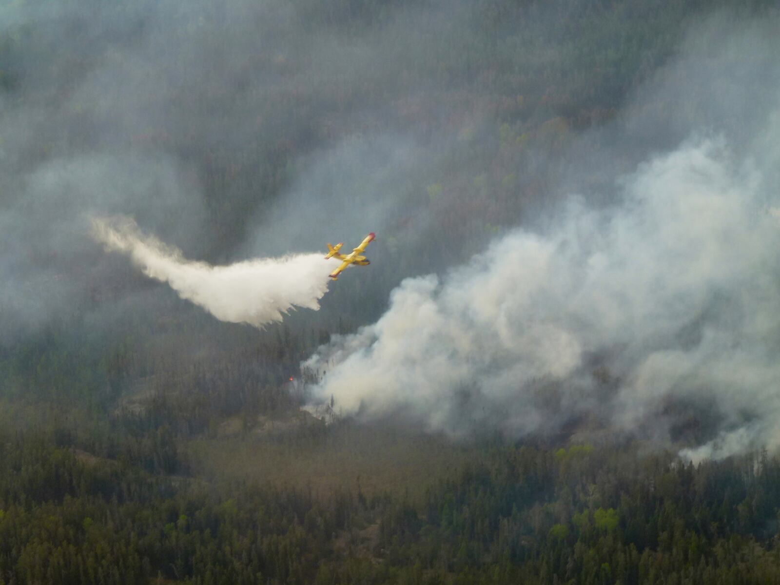 A water bomber aircraft battles a wildfire in southeast Manitoba as shown in this handout photo provided by the Manitoba government on Tuesday, May 27, 2025. (Manitoba government via The Canadian Press via AP)