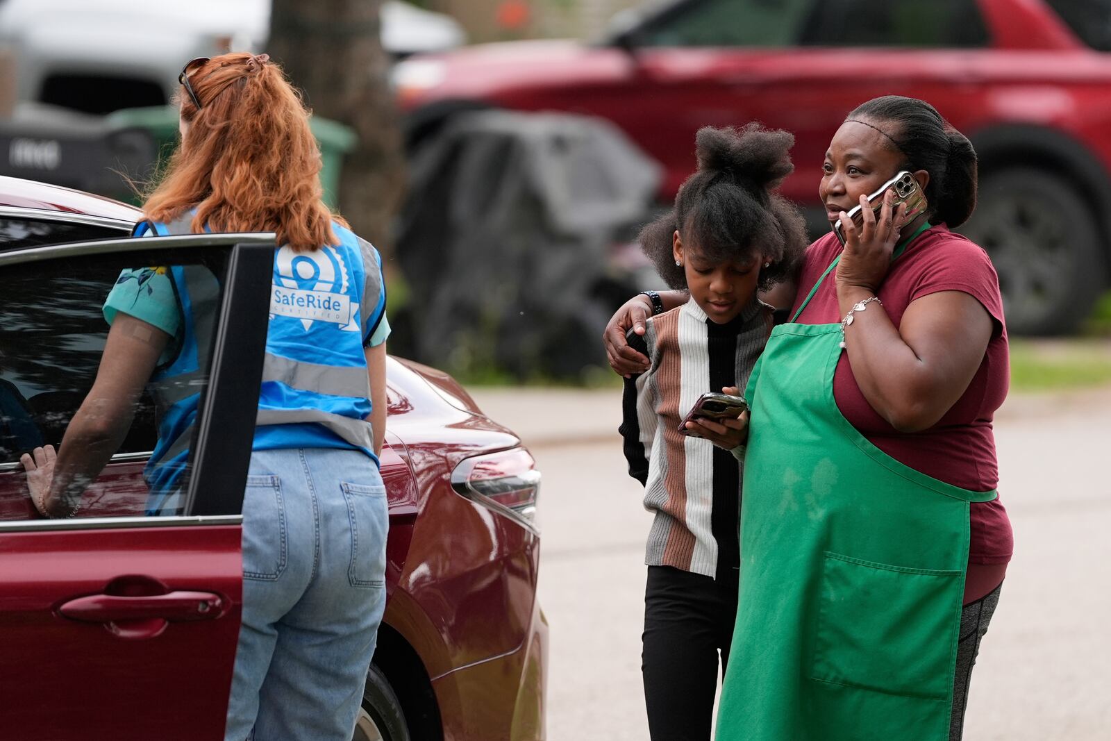 Crystal Holmes, right, greets her granddaughter, Mackenzie Holmes, 10, as she arrives at Mission of Yahweh women's shelter after school on Tuesday, April 1, 2025, in Houston. A service provides transportation to and from school for Mackenzie. (AP Photo/Ashley Landis)