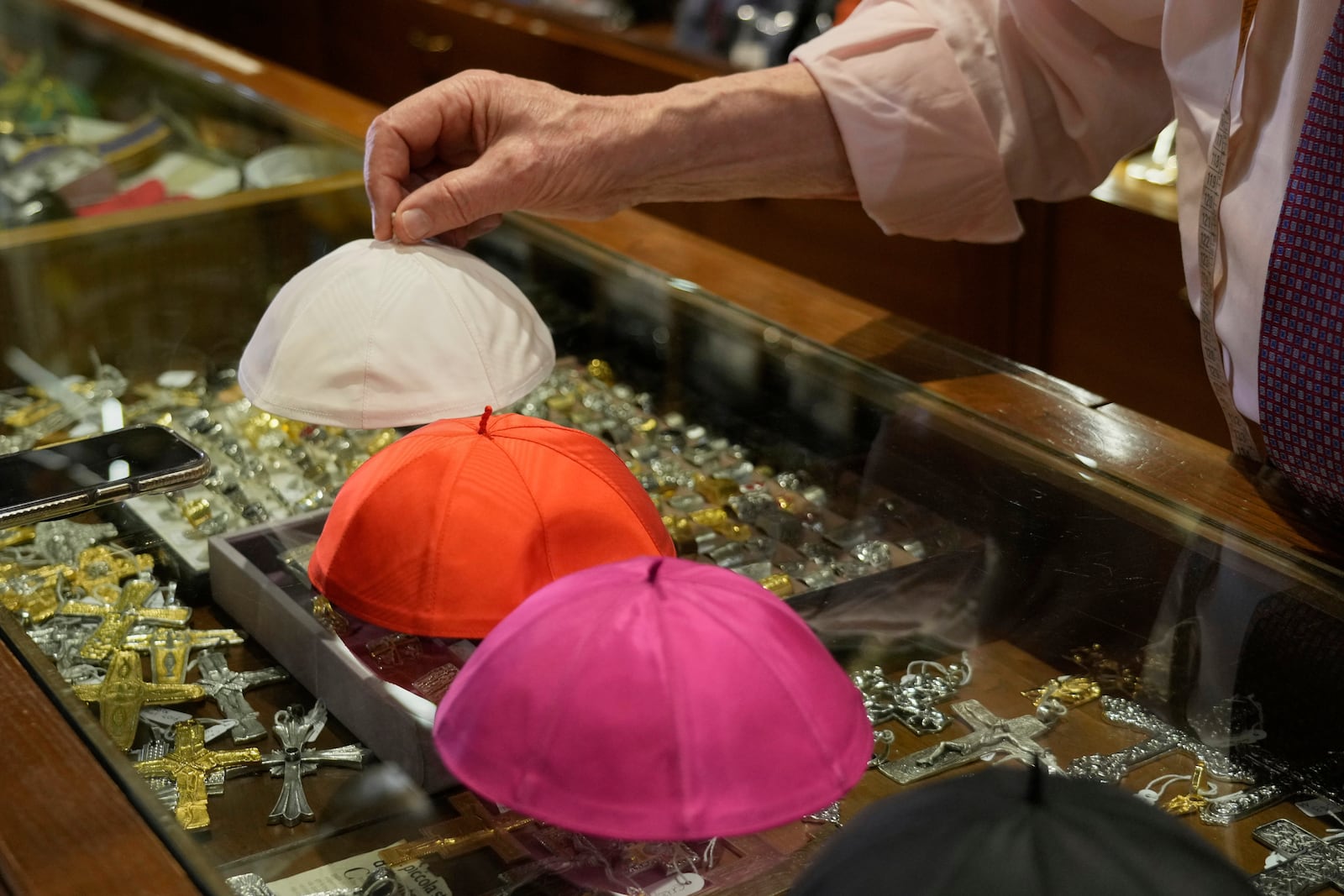 Italian tailor Raniero Mancinelli, who on his own initiative is making outfits for a possible future Pope, shows a pontiff's skull cap as he is interviewed by the Associated Press inside his shop, in Rome, Wednesday, April 30, 2025. (AP Photo/Gregorio Borgia)