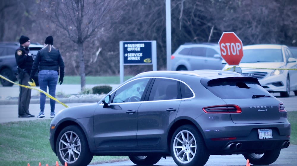 A vehicle with evidence markers near its front wheel after a shooting incident in the Sportsplex parking lot near Dayton Road on Sunday, Nov. 30, 2025 in Fairborn. MARSHALL GORBY / CONTRIBUTED PHOTO