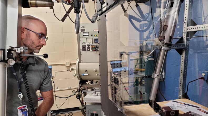 Matt Johnson, a senior systems engineer in the power and energy division at the University of Dayton Research Institute, demonstrates equipment used to support the development of power systems for space. UDRI photo