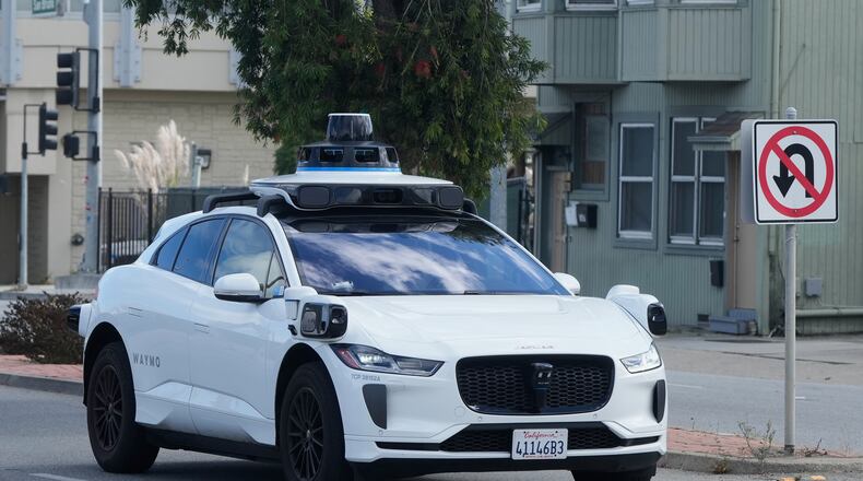 A Waymo vehicle drives past a No U-Turn sign in San Bruno, Calif., Tuesday, Sept. 30, 2025. (AP Photo/Jeff Chiu)