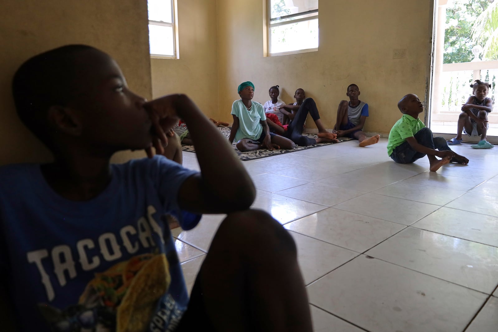 Children watch a movie after receiving their medication at the Caring for Haitian Orphans with AIDS orphanage, in Balan, Plaine-du-Nord, Haiti, Wednesday, May 21, 2025. (AP Photo/Patrice Noel)