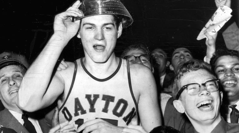 3-24-1962 NEW YORK: Big Bill Chmielewski, who led Dayton to a 73-67 victory over St. John's in the finals of the National Invitation Basketball Tournament, is mobbed by delirious fans at the end of the game. On his head is the trophy he received as the most valuable player. UPI TELEPHOTO