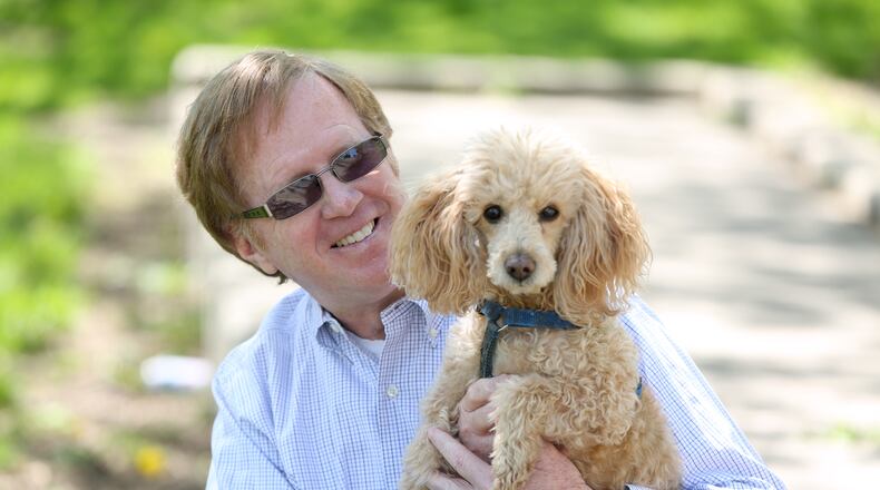 Jim Garvey takes his dog Pluto on daily walks in downtown Dayton, posting photos and sharing history lessons about the Gem City to cheer his friends on social media during the coronavirus pandemic. LISA POWELL / STAFF