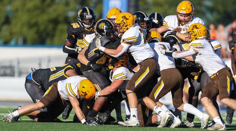 A Meadowdale High School ballcarrier is swarmed by several Alter High School defenders during a football game at Welcome Stadium on Thursday, Aug. 31, 2023. Contributed photo / Michael Cooper