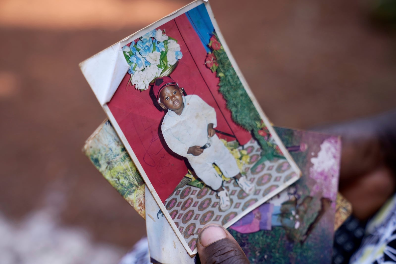 Susan Njeri, 44 years old, whose son Boniface Kariuki was shot at close range by a Kenyan police officer during a protest, holds his picture in Muranga, Kenya, Wednesday, June 18, 2025. (AP Photo/Brian Inganga)