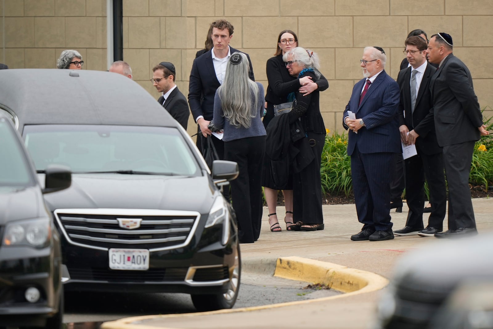 Family and friends gather outside Congregation Beth Torah after a funeral for Sarah Milgrim, a staffer at the Israeli Embassy who was killed last week outside a Washington Jewish museum, Tuesday, May 27, 2025, in Overland Park, Kan. (AP Photo/Charlie Riedel)