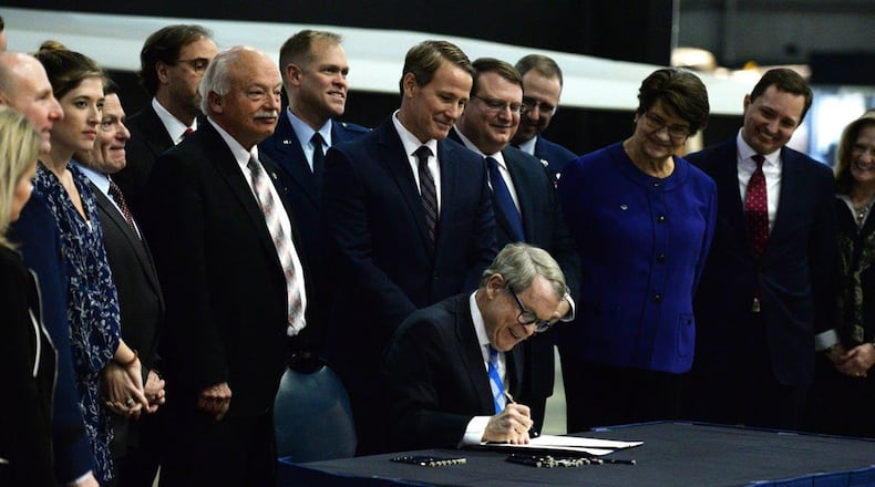 Ohio Gov. Mike DeWine signs Senate Bill 7 into law at the National Museum of the United States Air Force Jan. 27. The bill mandates Ohio agencies to issue licenses or certificates to qualifying military members and their spouses. (U.S. Air Force photo/Wesley Farnsworth)