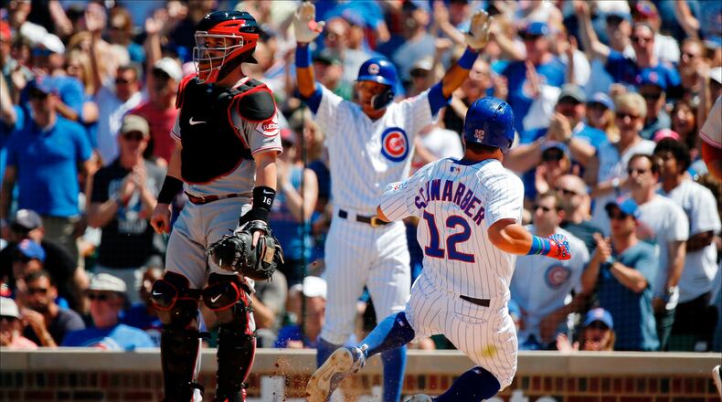CHICAGO, IL - JULY 07: Kyle Schwarber #12 of the Chicago Cubs scores on an RBI double against the Cincinnati Reds hit by Victor Caratini #7 (not pictured) during the fourth inning at Wrigley Field on July 7, 2018 in Chicago, Illinois. (Photo by Jon Durr/Getty Images)