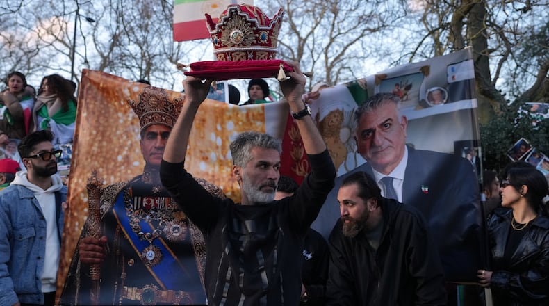 A protester holds a crown in London, Saturday, Feb. 28, 2026 after U.S. and Israeli forces carried out a series of strikes on Iran on Saturday morning. (AP Photo/Alastair Grant)