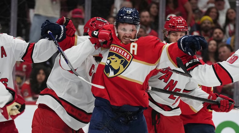 FILE - Florida Panthers left wing Matthew Tkachuk (19) scuffles with Carolina Hurricanes players during the second period in Game 3 of the NHL hockey Stanley Cup Eastern Conference finals Saturday, May 24, 2025, in Sunrise, Fla. (AP Photo/Lynne Sladky, File)