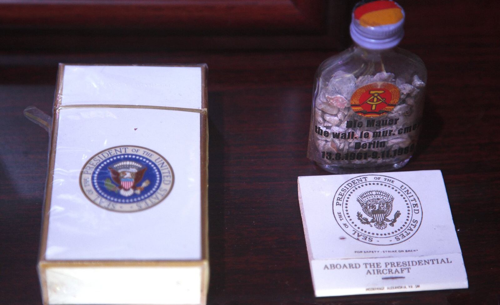 A pack of cigarettes and a book of matches embossed with the seal of the United States of America taken from President Kennedy’s Air Force One and a glass jar holding fragments of the Berlin Wall are part of the Dayton International Peace Museum exhibit, Glory and Tragedy: JFK and RFK, 1960-1968. LISA POWELL / STAFF