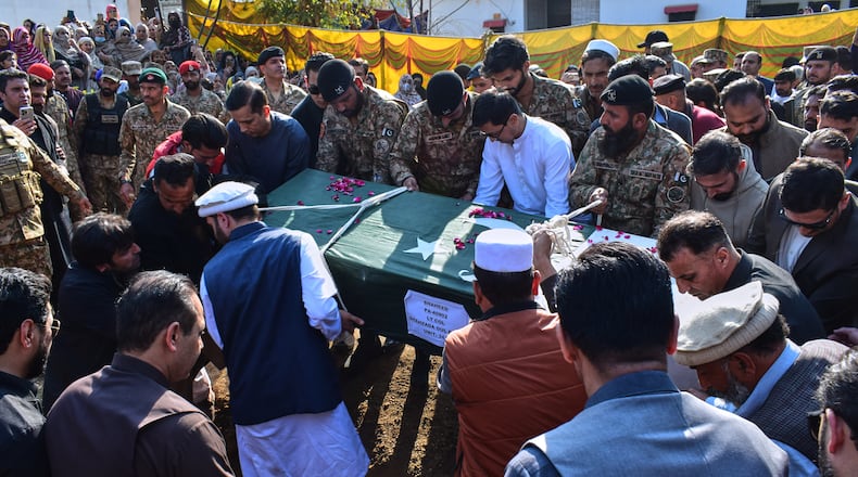 Relatives and army soldiers carry the casket of an army officer, who was killed in the suicide bombing in the border district of Bannu, for his burial following a funeral prayer in Mansehra, Pakistan, Sunday, Feb. 22, 2026. (AP Photo/Saqib Manzoor)