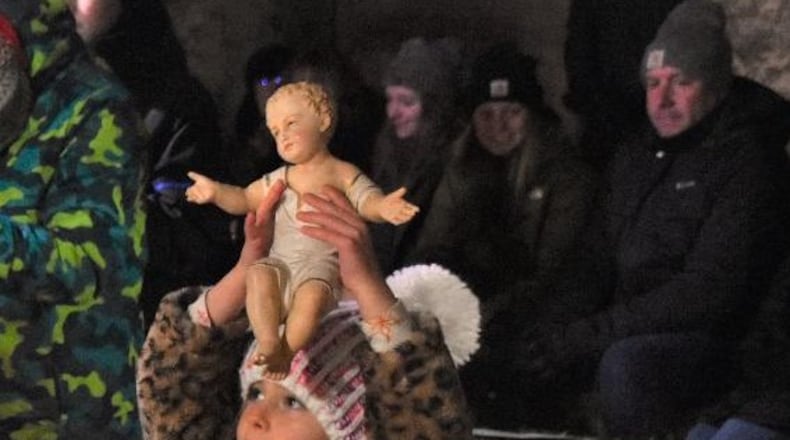 Granddaughter Evelyn Westendorf, now 6, presents the Baby Jesus that’s part of the evening each year. The statue is over 100 years old and came from Susie’s grandma and is from Germany. Evelyn is one of the Westendorf’s 11 grandchildren. CONTRIBUTED