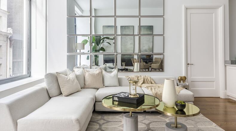 Identical rectangular mirrors hung in a grid pattern help add height to a loftlike living space. (Design Recipes)