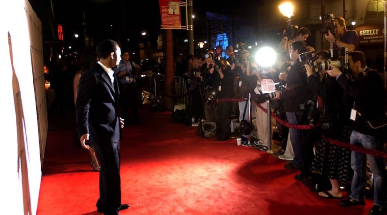 Springfield native John Legend poses for a wall of photographers as he walks down the red carpet to the Sony  party in Hollywood after winning three Grammy Awards in 2006. MARSHALL GORBY / STAFF