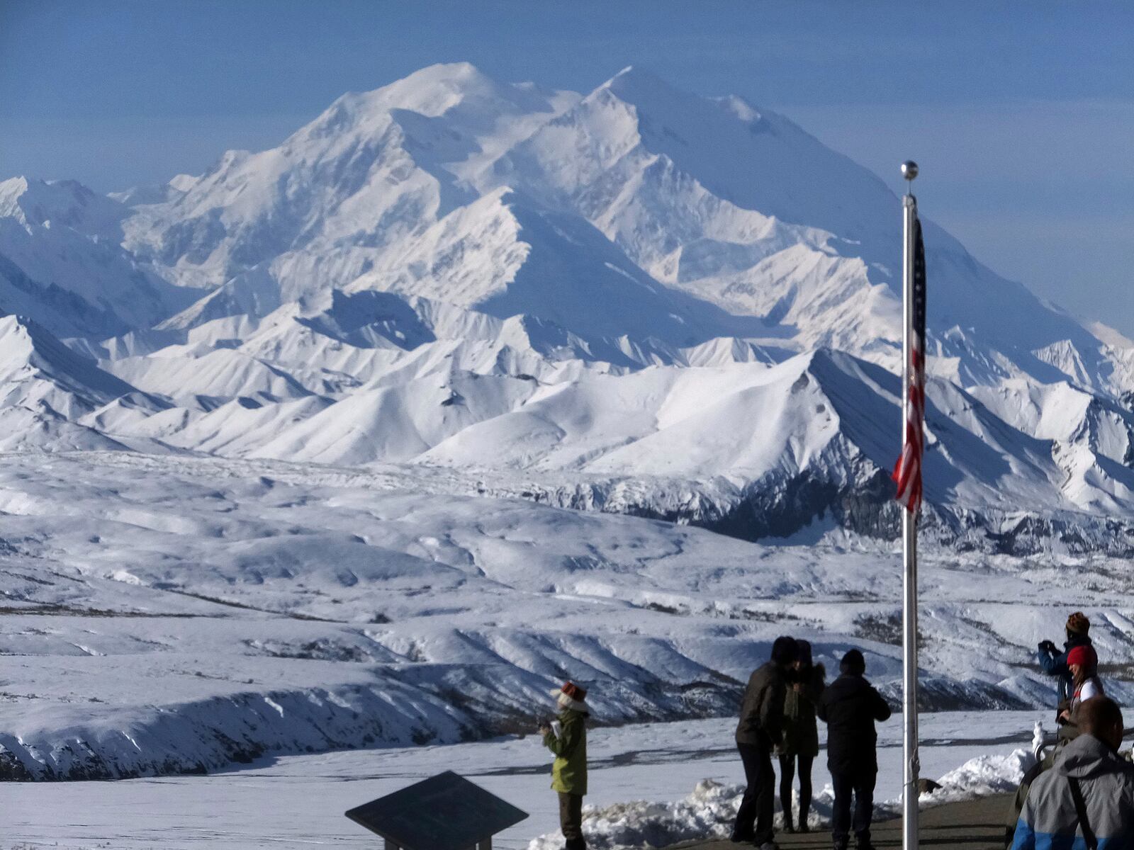 FILE - People stand at the Eielson Visitor Center with a view of North America's tallest peak, Denali, in the background, Sept. 2, 2015, in Denali National Park and Preserve, Alaska. (AP Photo/Becky Bohrer, File)