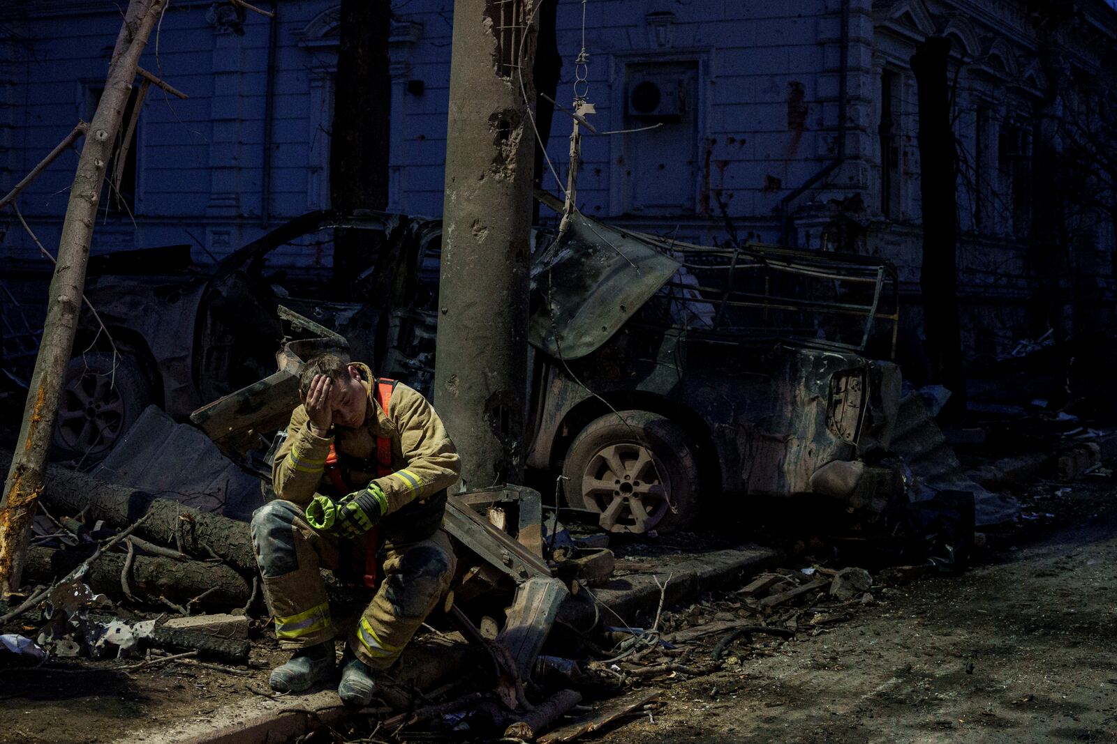 A rescue worker rests near university building destroyed by a Russian missile strike on Sumy, Ukraine, Sunday, April 13, 2025. (AP Photo/Evgeniy Maloletka)