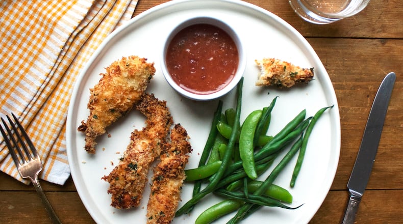 This image shows a recipe for crispy chicken strips with an apricot mustard dipping sauce. (Katie Workman via AP)